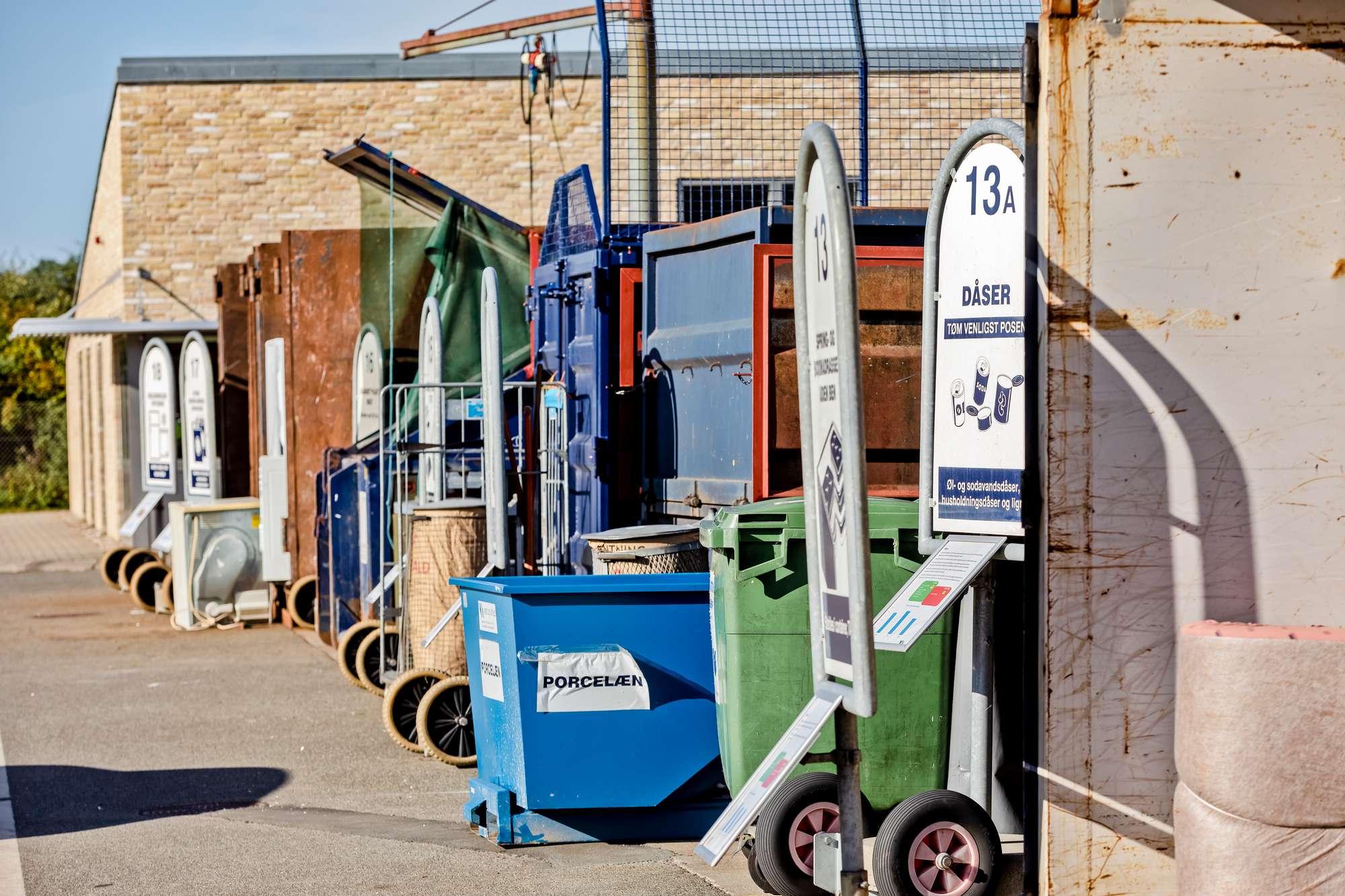 Containere og skilte på stribe på genbrugsstationen på Miljøvej.